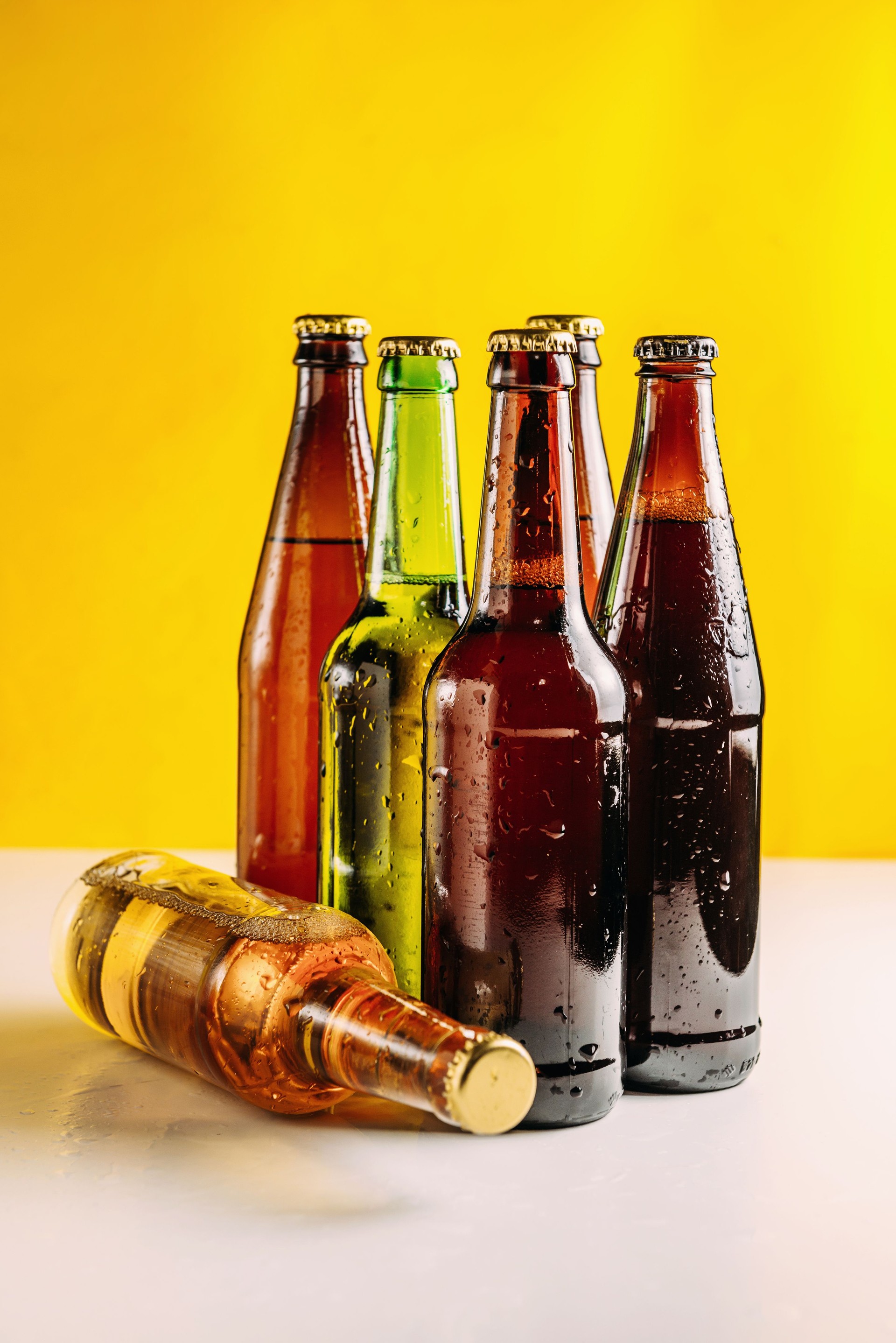 Bottles of beer in different colors. Light and dark beer. Beer background for advertising, chilled drink